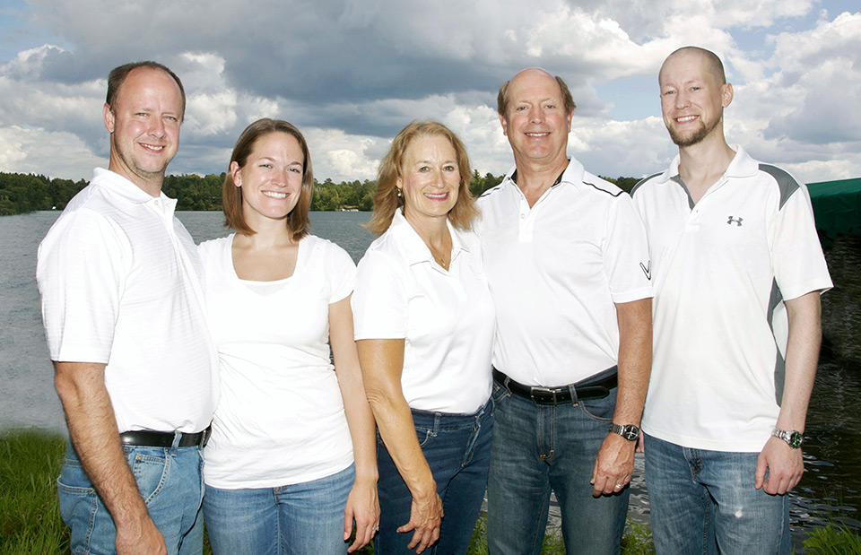 The Carter family in white t shirts and jeans on a lake shore